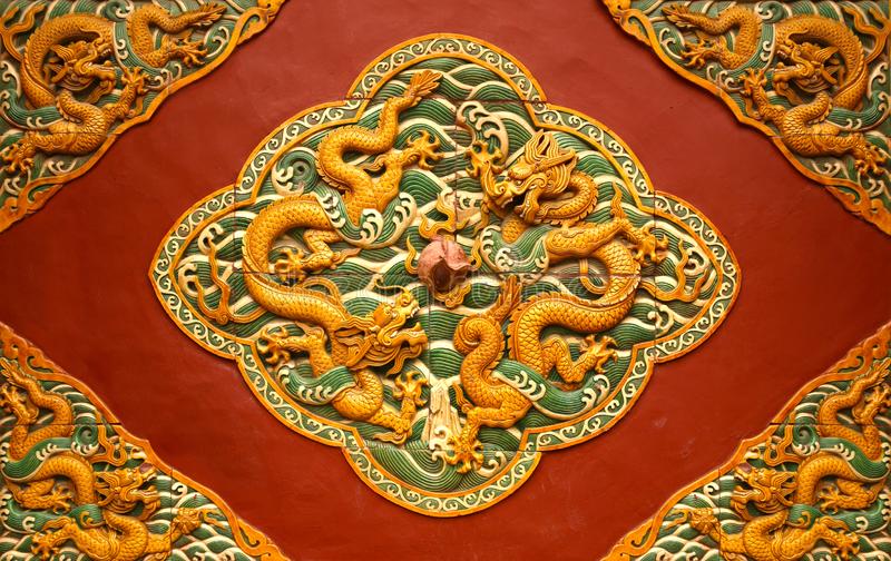 Fretwork in the form of a dragon on the red wall in the Forbidden City. Beijing,