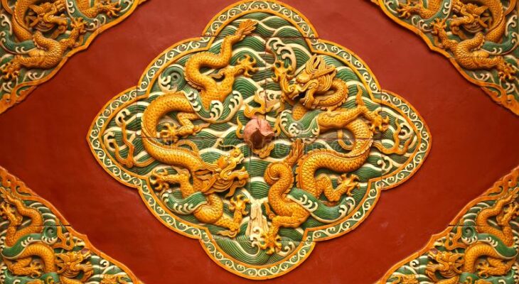 Fretwork in the form of a dragon on the red wall in the Forbidden City. Beijing,